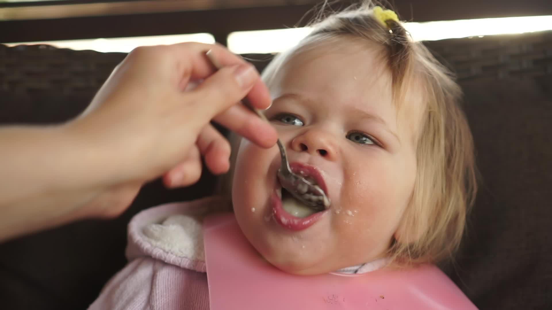 胖乎乎的女婴热闹地张开嘴吃着美味的牛奶食物视频的预览图