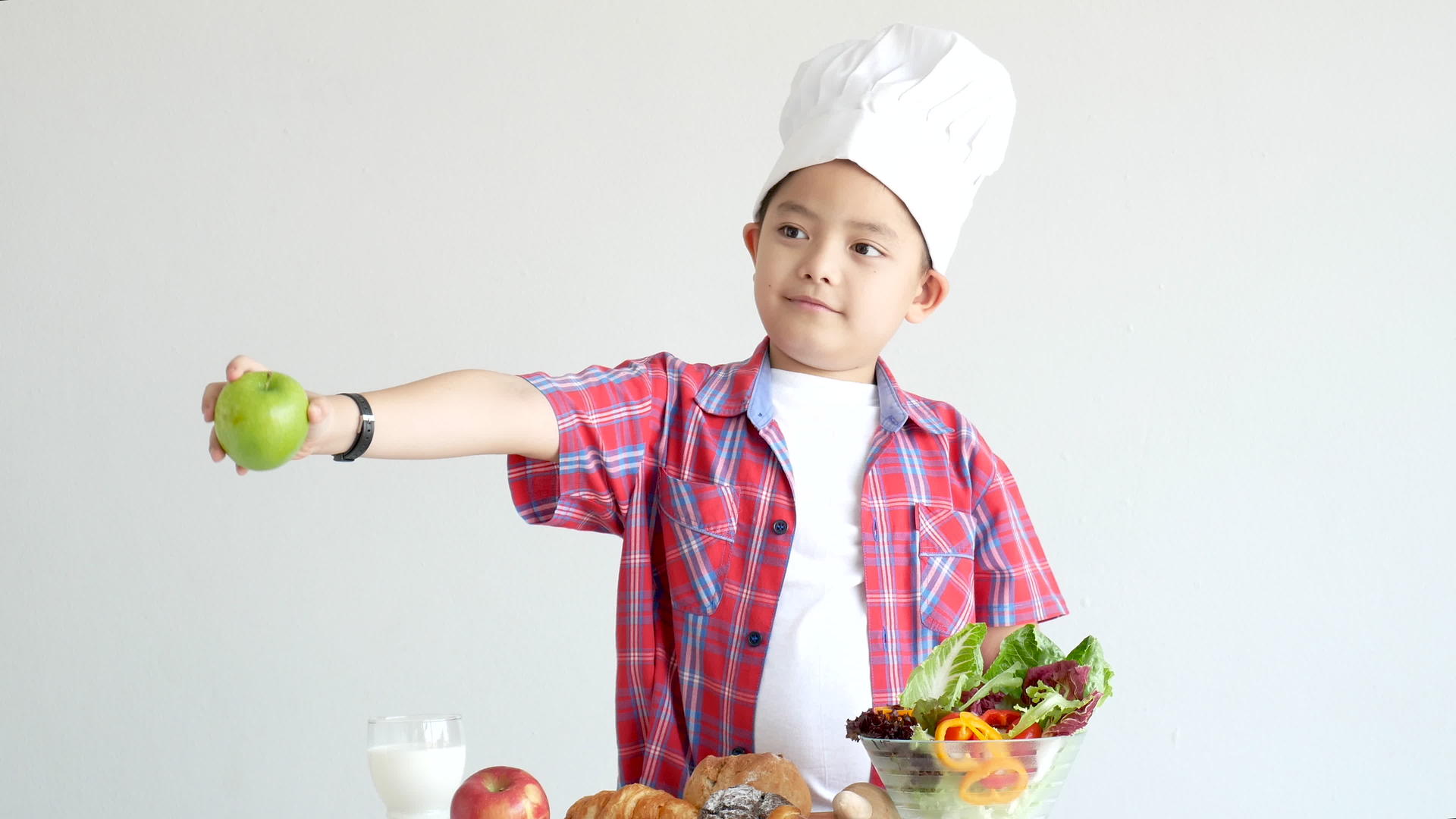 男孩拿着苹果站在有机食品前面包括蔬菜视频的预览图