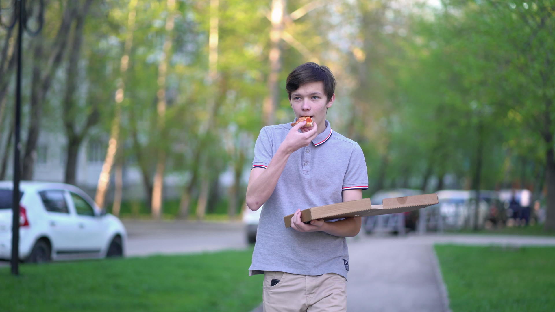 一个人在城市里散步吃披萨视频的预览图