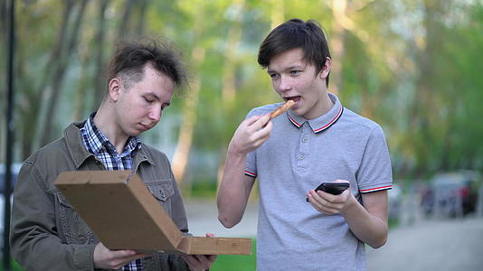 两个朋友在户外吃披萨街头食物的概念视频的预览图