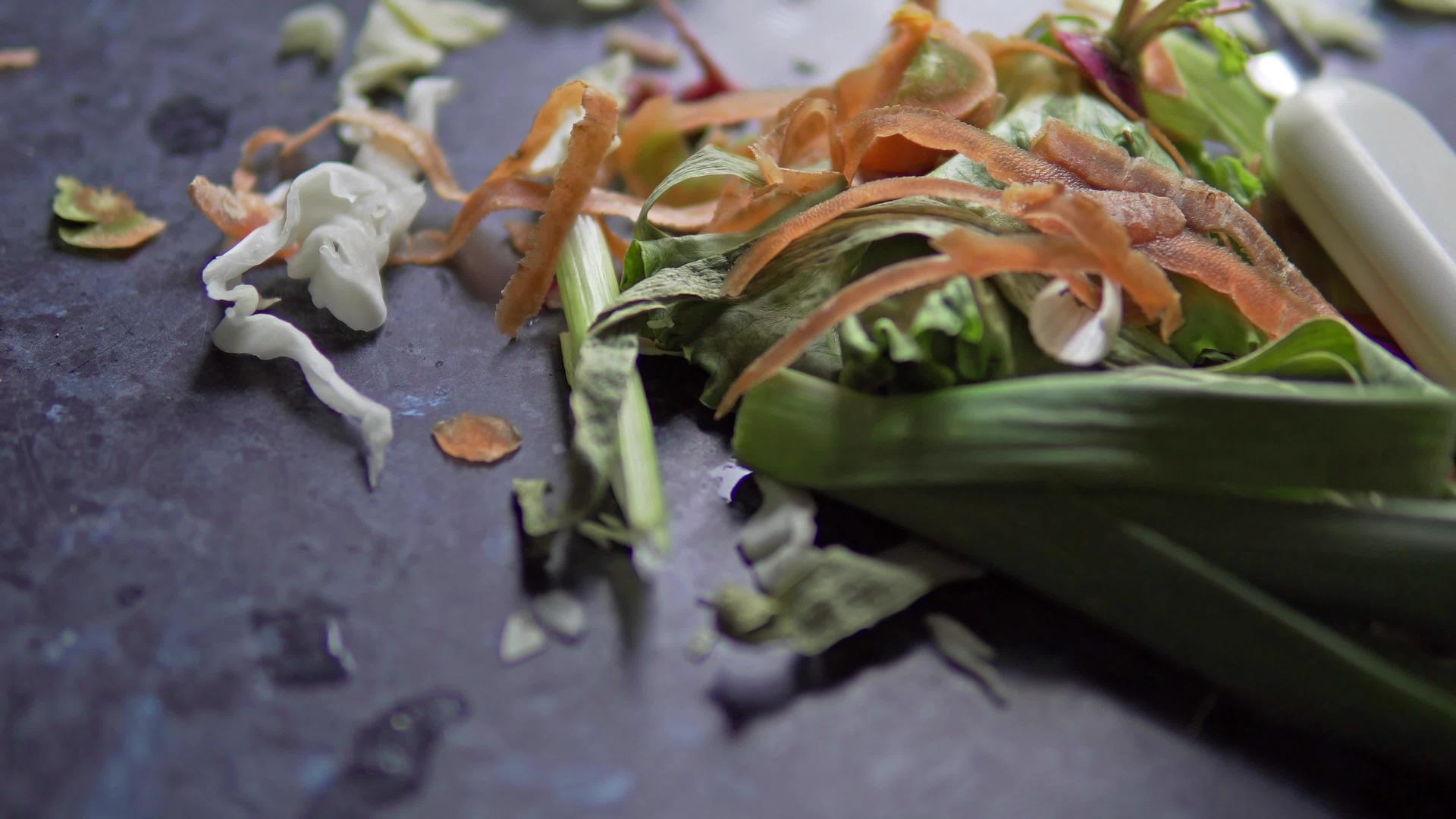 厨房餐桌上的排水胡萝卜、黄瓜和黄瓜上的蔬菜废料视频的预览图