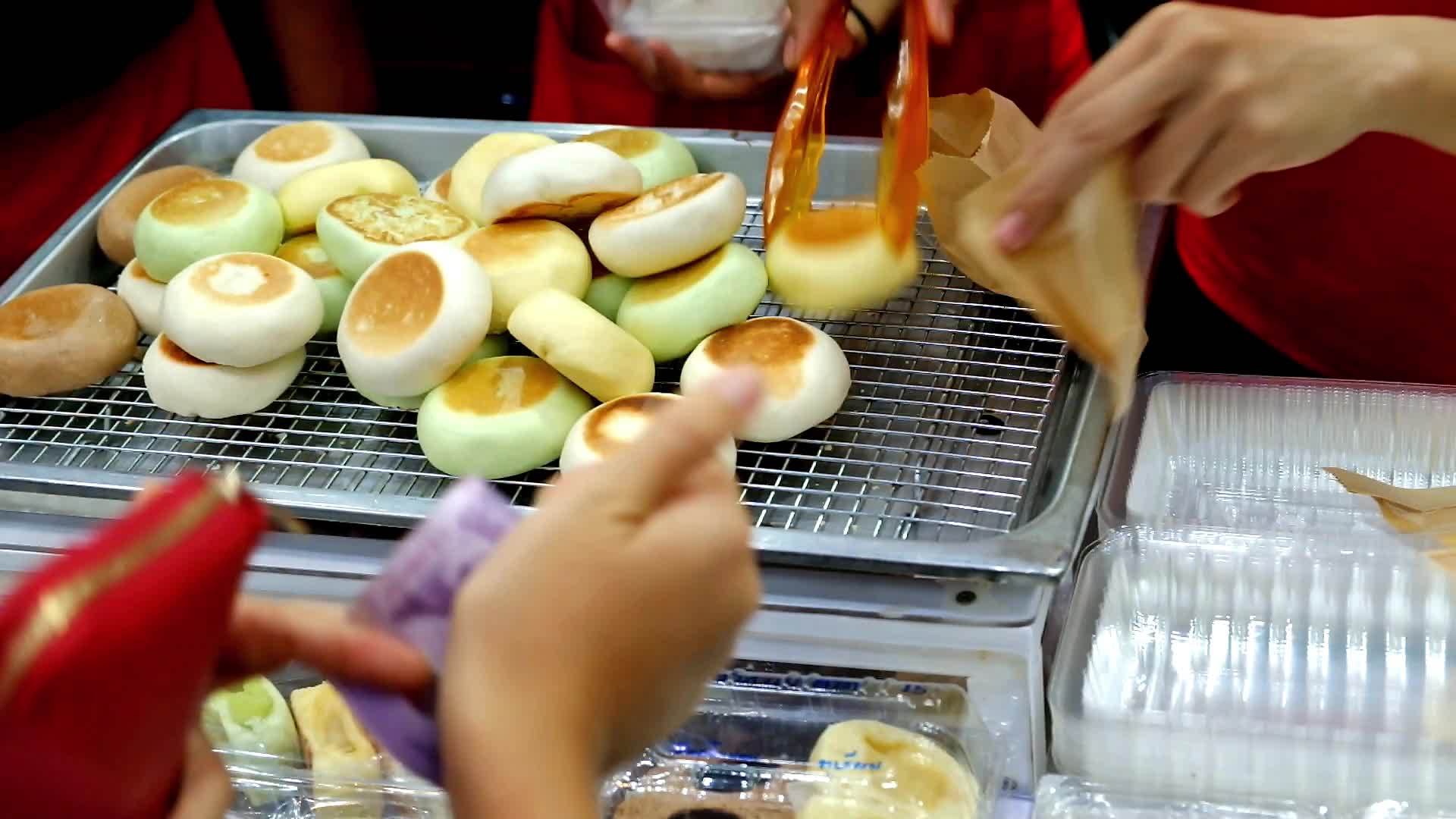 年轻的小卖家卖新鲜的烤奶油面包给顾客视频的预览图