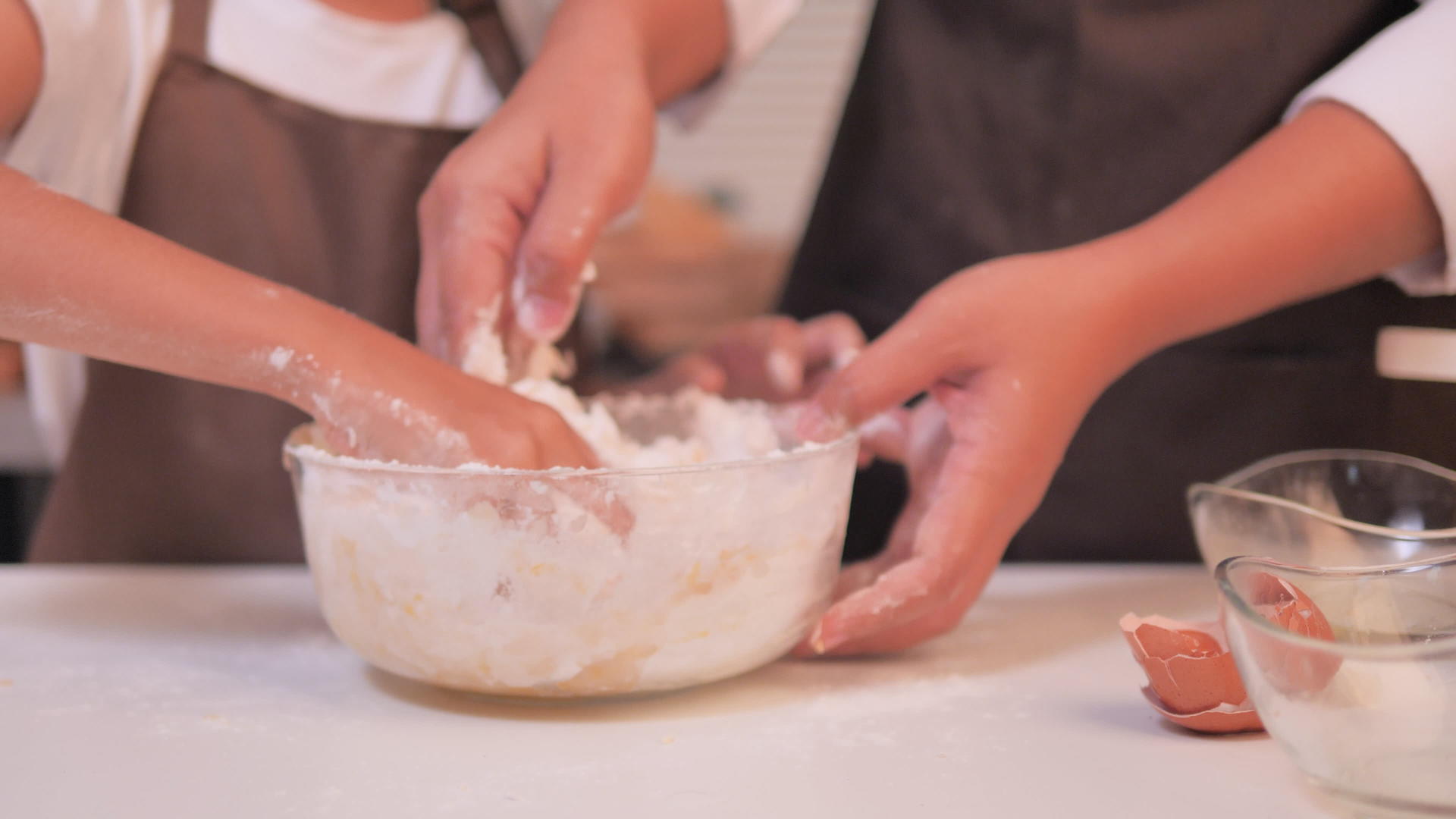 母女俩帮忙把搅拌碗里的面粉搅拌在一起做成了自制的面粉视频的预览图