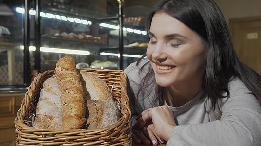 闻到新鲜面包的香味后快乐的年轻女子对着相机微笑视频的预览图