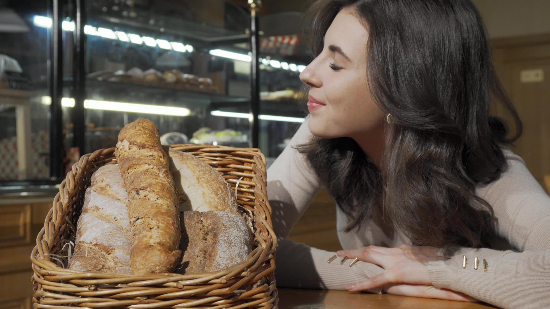 美女们在面包店的篮子里闻到新鲜的烤面包的味道视频的预览图