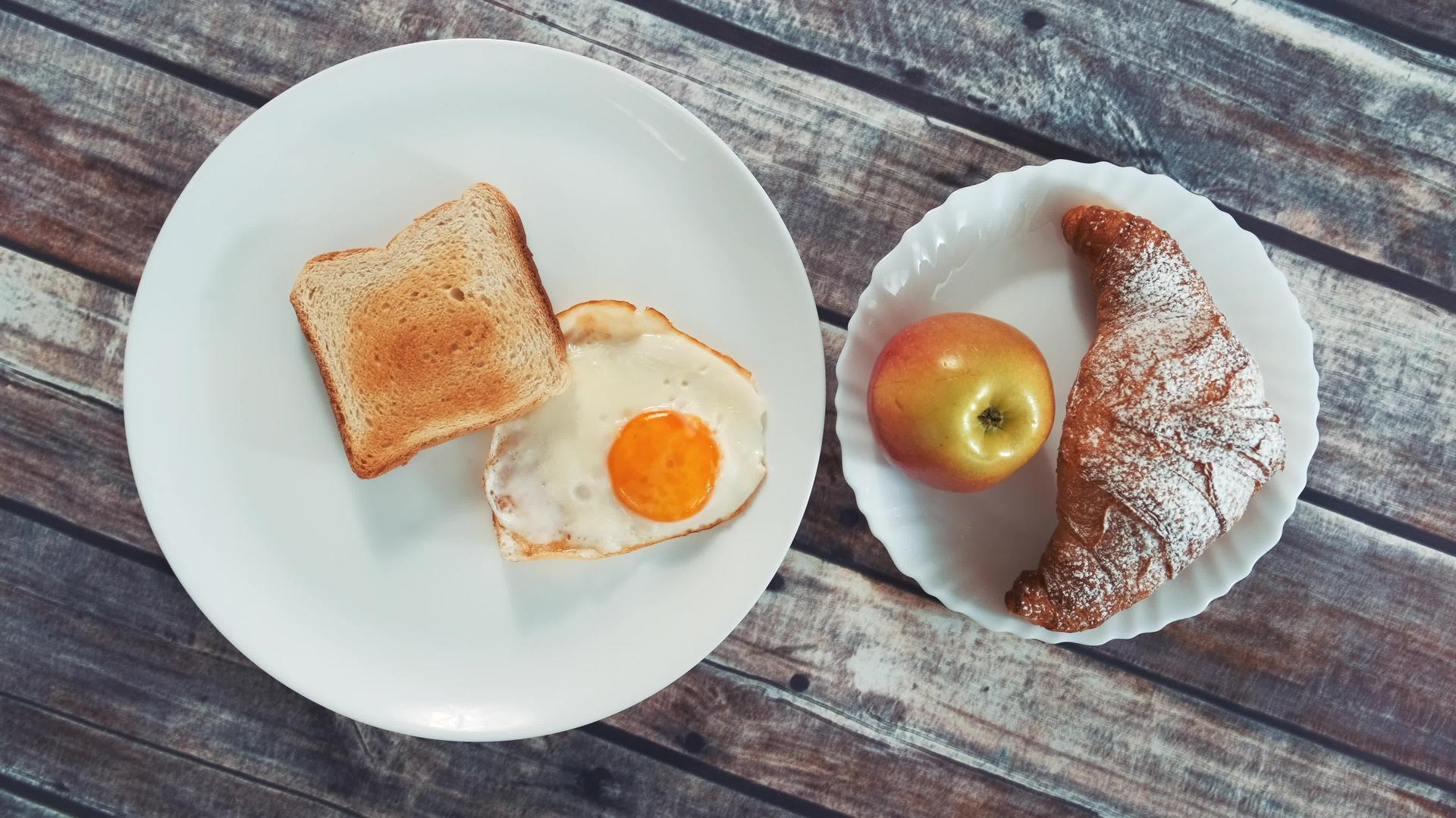 美味的早餐煎蛋吐司苹果和羊角面包视频的预览图