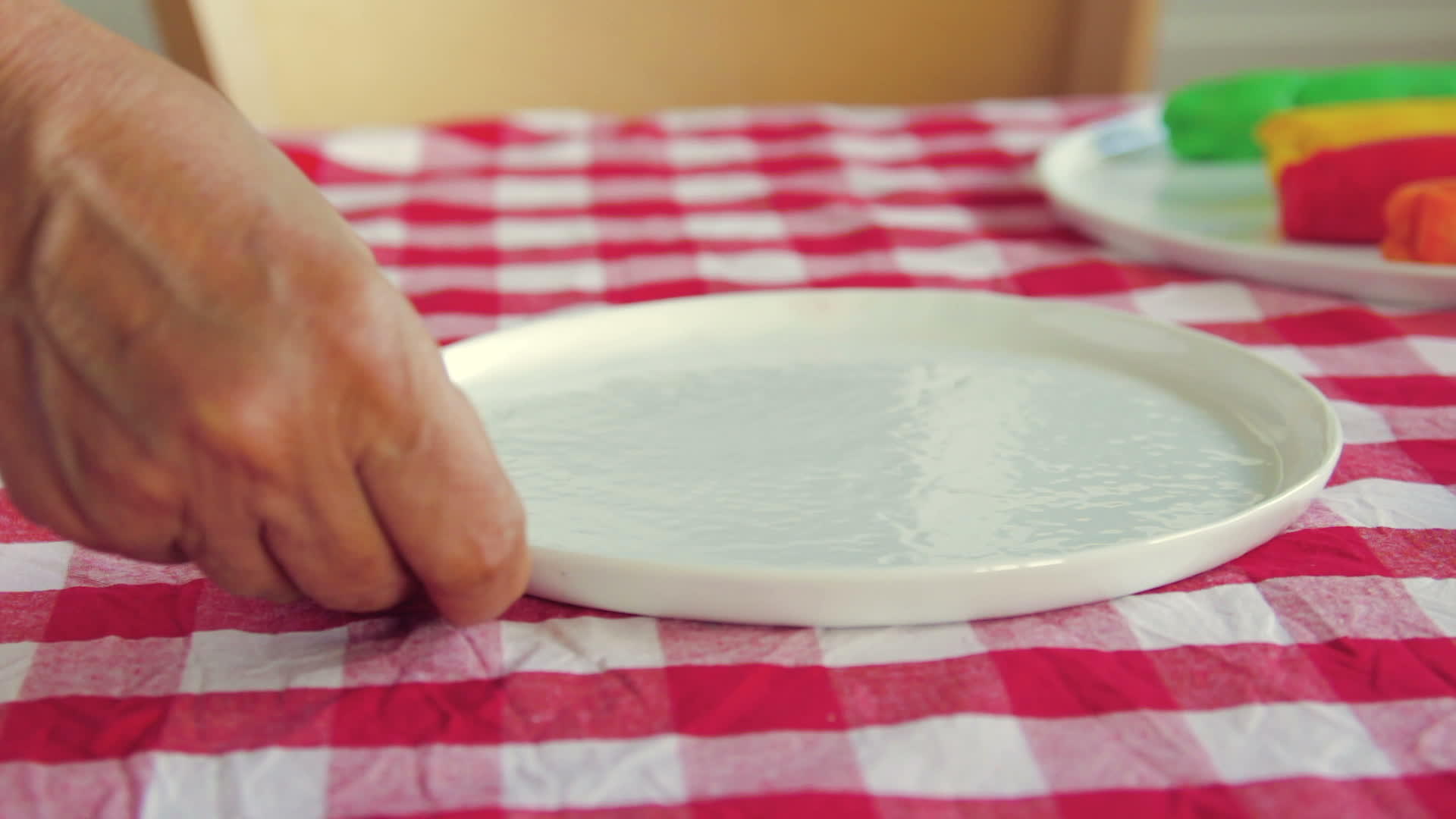 女人把白色的空盘子放在桌子上视频的预览图
