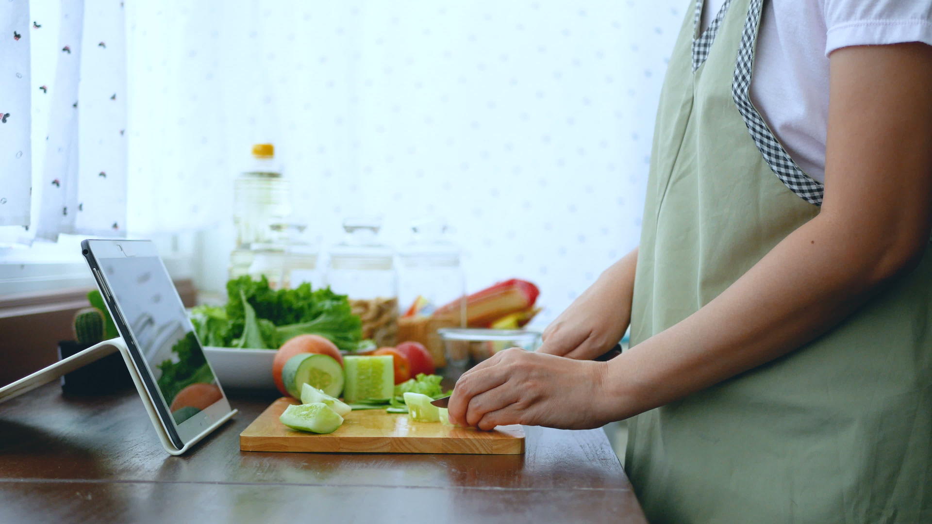4K女性手工切新鲜生菜通过平板电脑准备烹饪原料视频的预览图