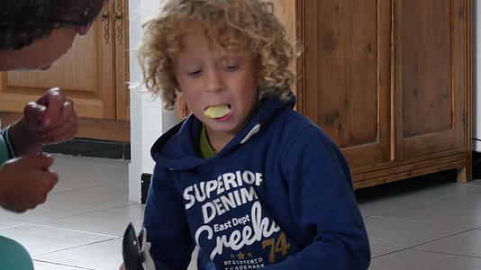 一个金发男孩吃了一个苹果切成碎片视频的预览图