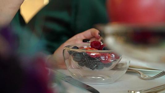 中年妇女从盘子里摘草莓视频的预览图