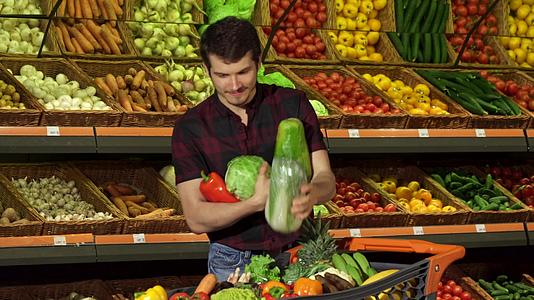 男人把不同的蔬菜放在购物车里视频的预览图