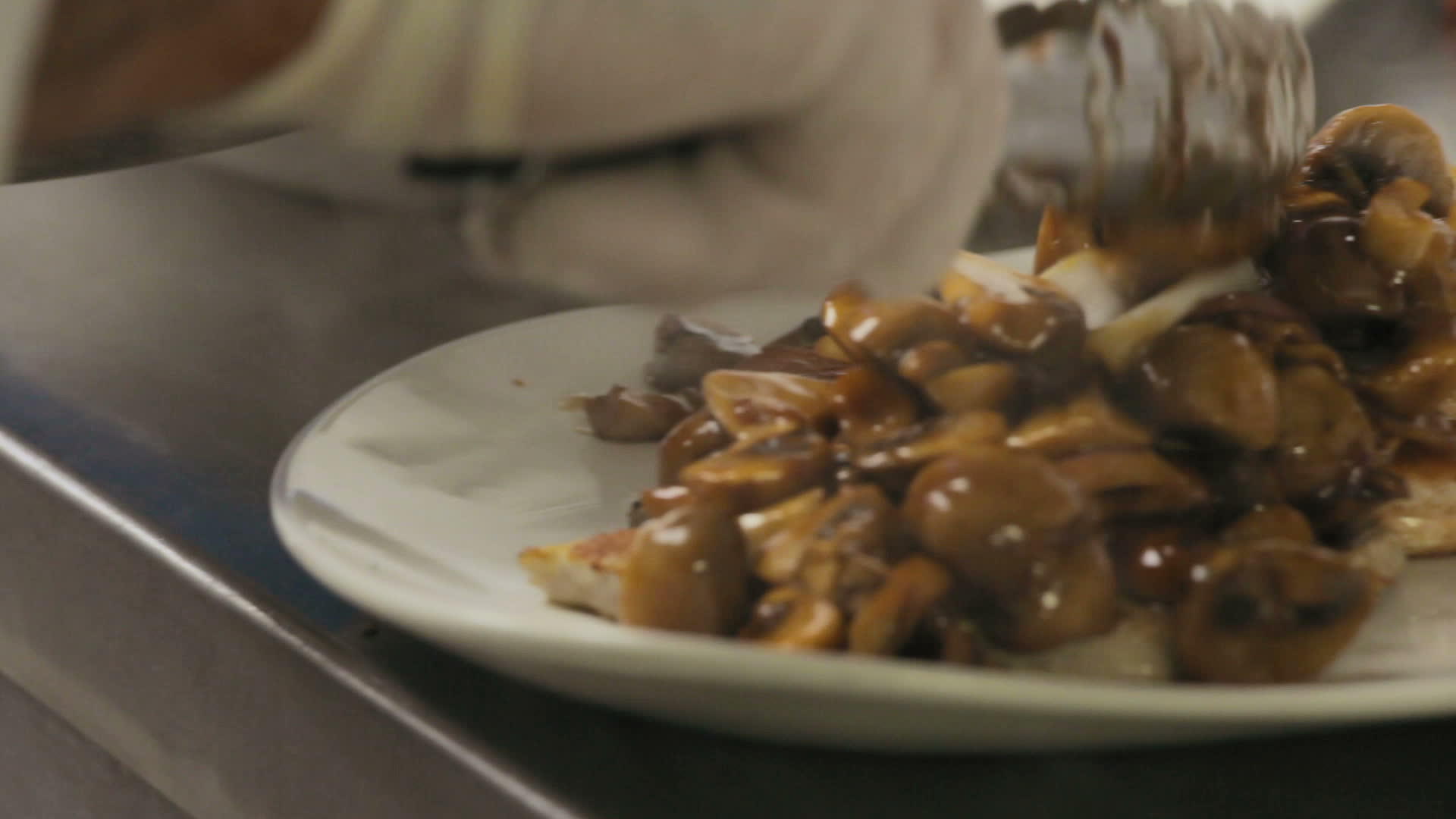厨师用蘑菇准备了一盘蔬菜酱蘑菇被烤鱼烧成白色的盘子视频的预览图