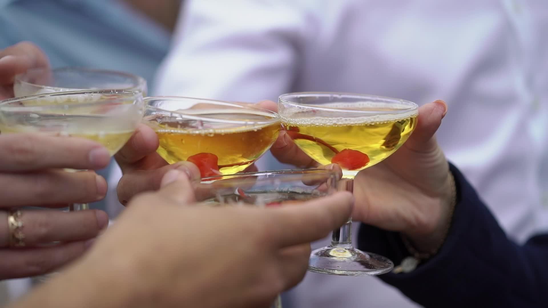 手里拿着酒杯、香槟或派对上其他酒精饮料的人把他们绑在一起视频的预览图