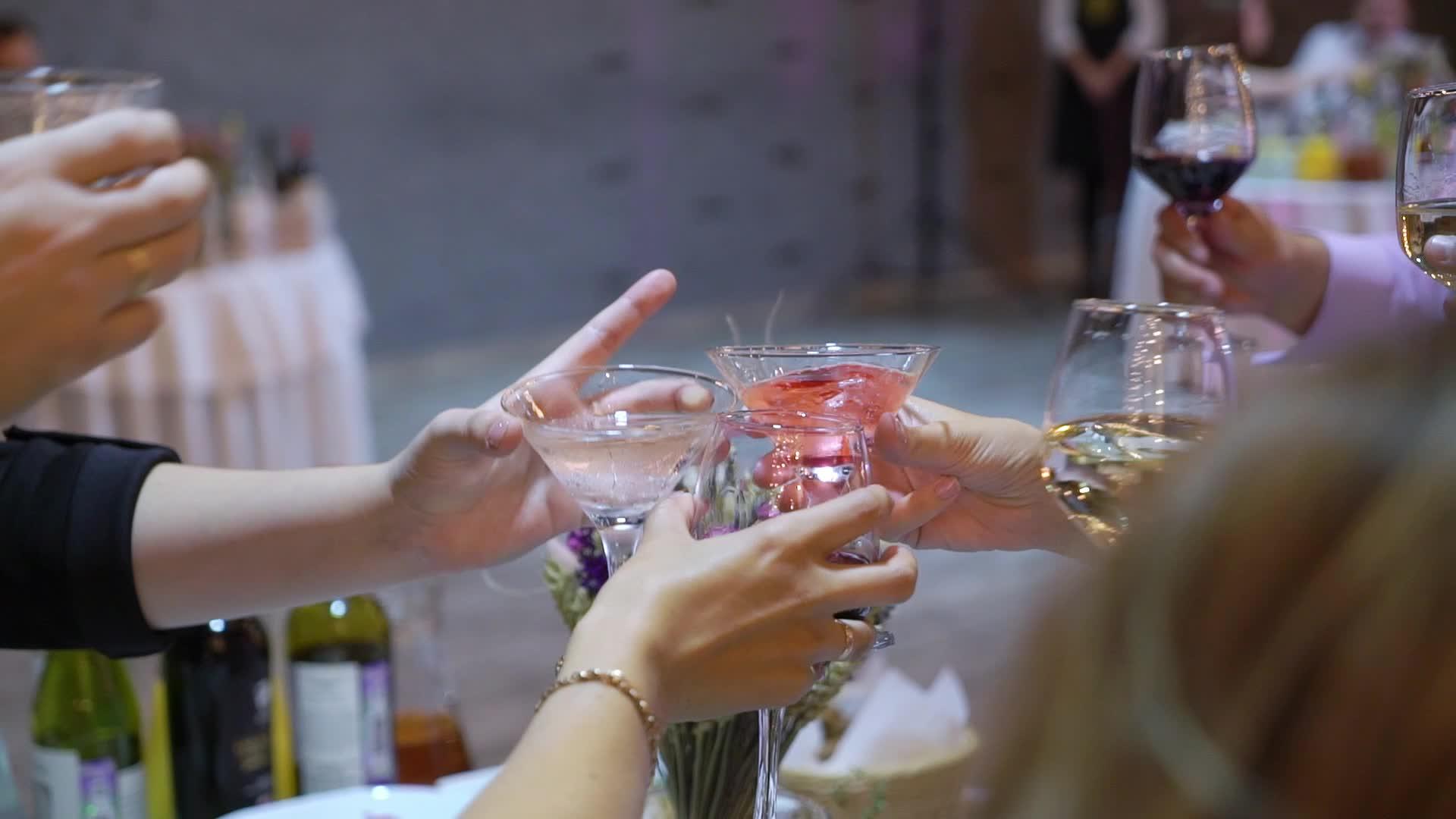 手里拿着酒杯、香槟或派对上其他酒精饮料的人把他们绑在一起视频的预览图