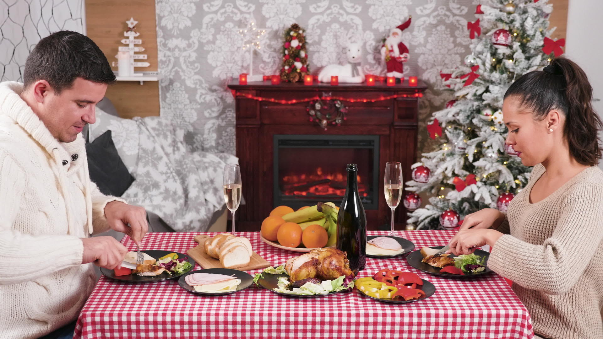 一对夫妇在圣诞晚餐桌上喝杯子和香槟视频的预览图