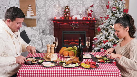 白人夫妇在壁炉前享用圣诞晚餐视频的预览图