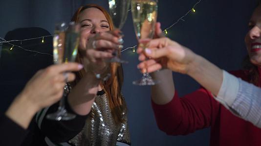 为庆祝圣诞节和新年做准备年轻女性用香槟碰杯视频的预览图