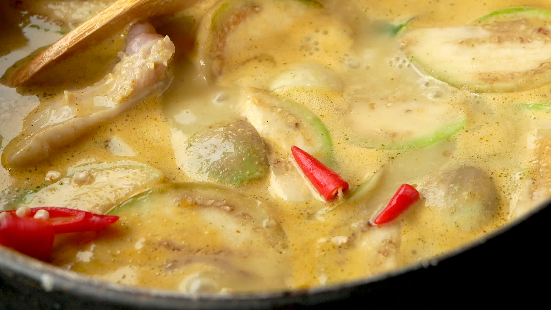鸡肉、蔬菜和咖喱在锅里煮视频的预览图