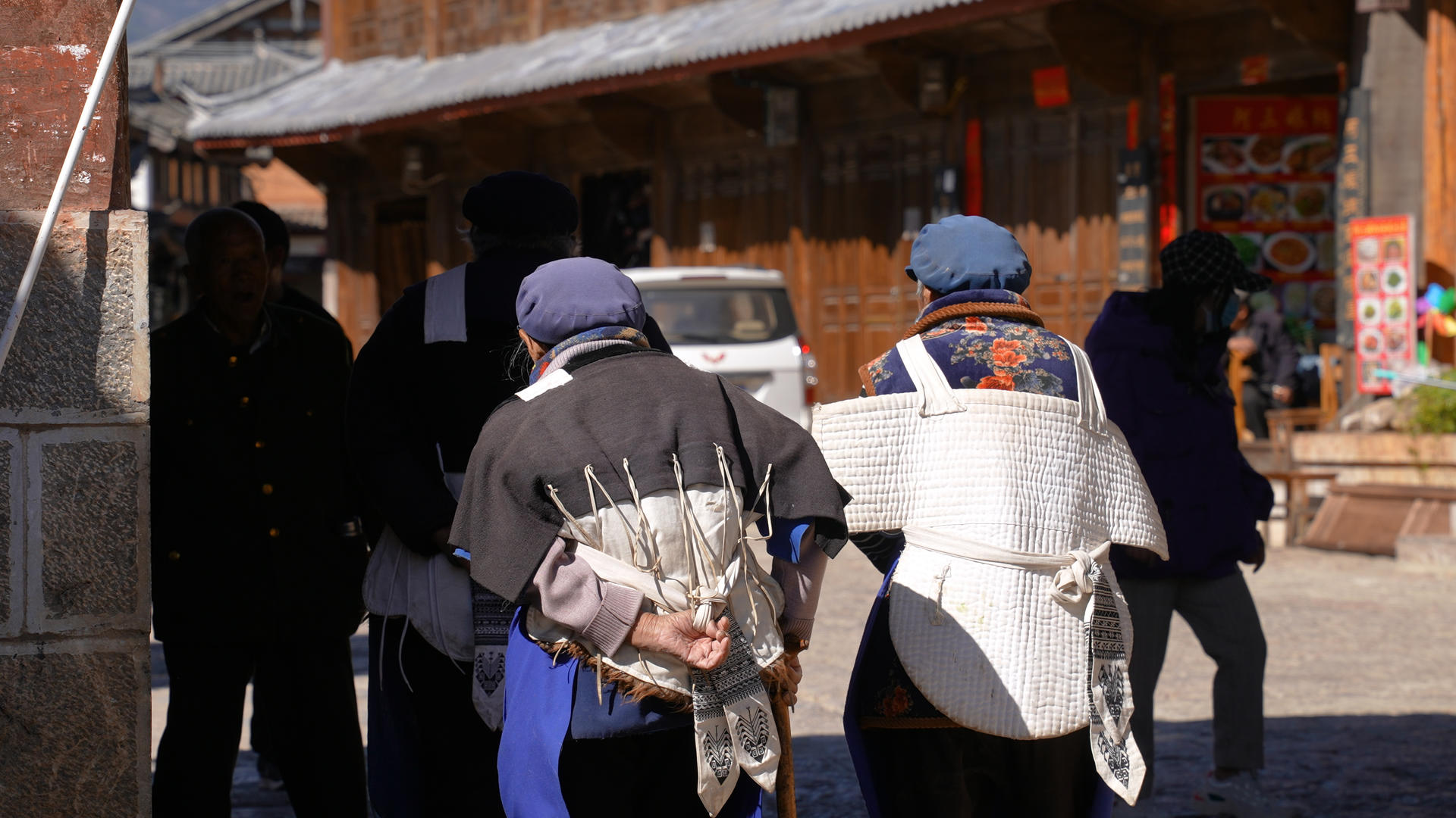 云南旅游丽江古城穿纳西族服饰的本地人背影4k素材视频的预览图