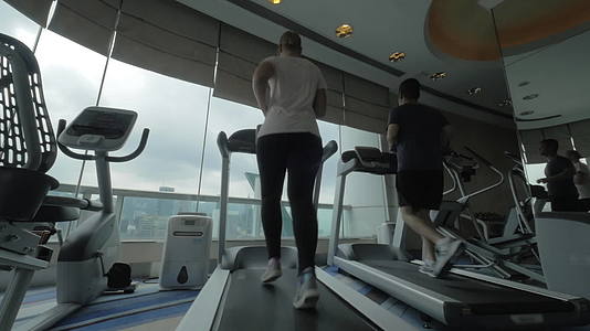 年轻男女在香港体育馆骑着跑步机跑来跑去视频的预览图