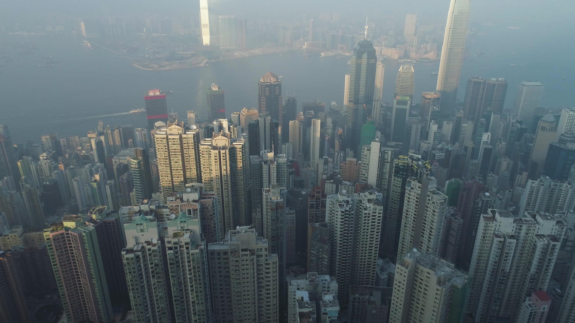 香港天际线和维多利亚港鸟瞰无人机向前飞行相机向上倾斜视频的预览图