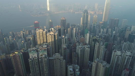 香港天际线和维多利亚港鸟瞰无人机向前飞行相机向上倾斜视频的预览图