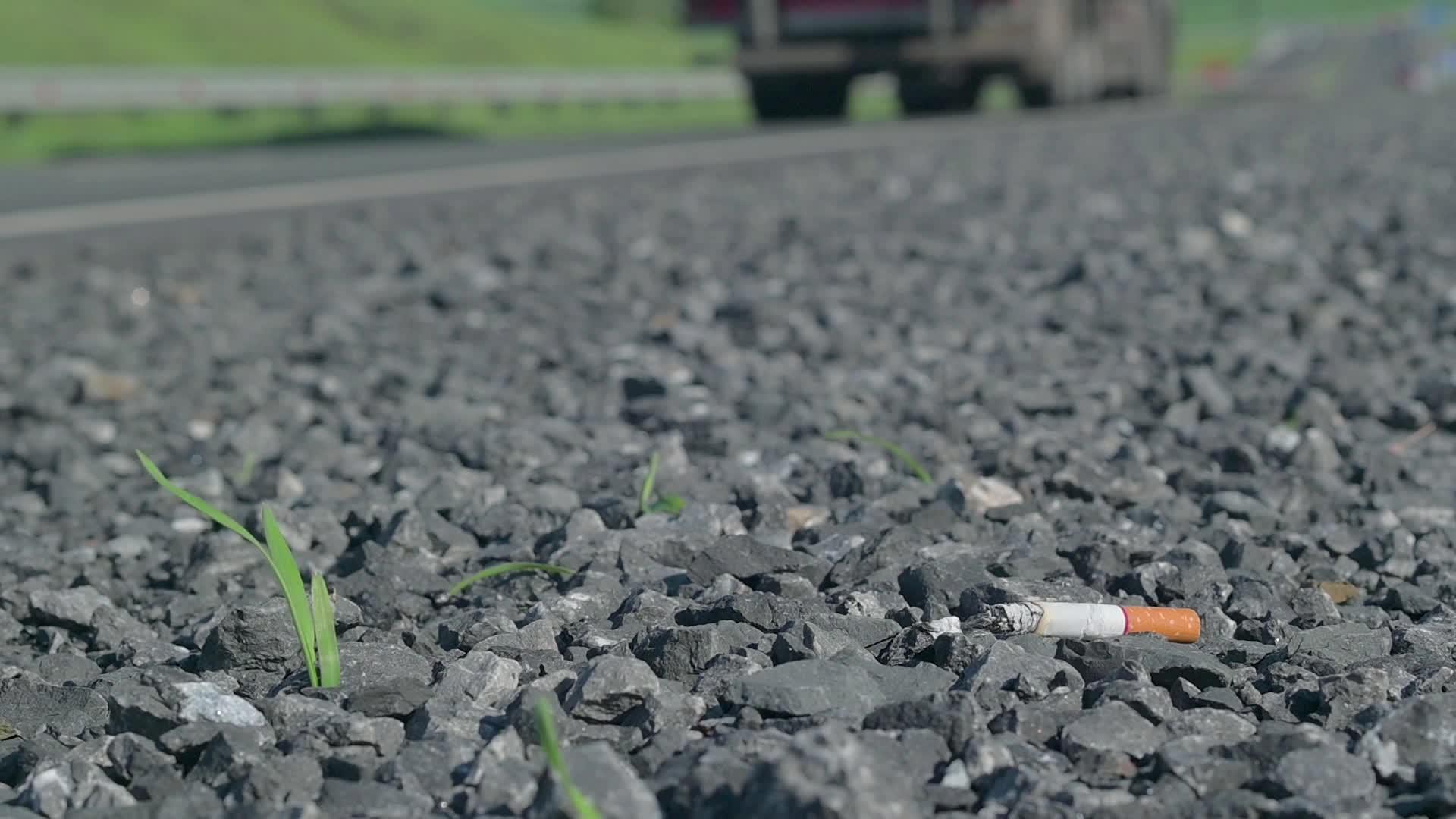 在多云的天气下一条乡村道路上的沥青上满是香烟视频的预览图