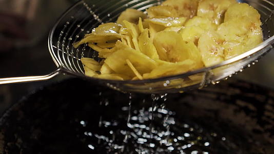 香蕉片在油腻的平底锅上油炸制作泰国甜点视频的预览图