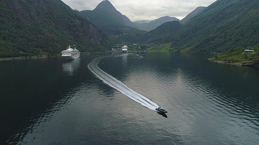 夏天盖朗厄尔峡湾的小型机动快艇和挪威的大型游轮鸟瞰图视频的预览图