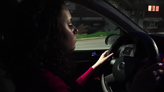 年轻、美丽、卷发、黑色西班牙妇女驾驶汽车的城市视频的预览图