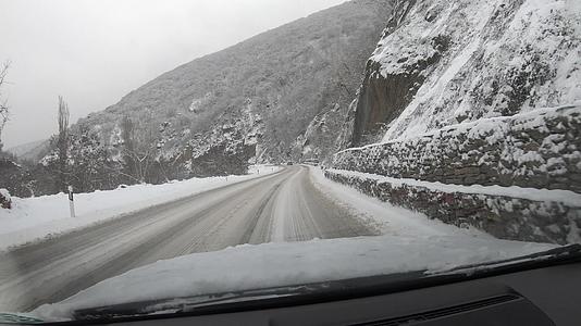 第一个视角是在冬天的暴风雨中开车去山区 在下雪的路上视频的预览图