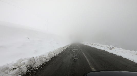 汽车在冬天的路上行驶在暴风雪的第一视角视频的预览图