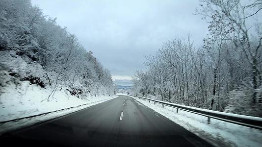冬季乡村道路上的汽车驾驶电影被雪挡风玻璃包围着视频的预览图