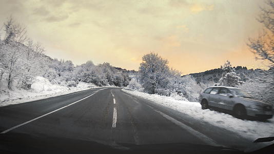 开车穿过冬天的日出 在霜冻的路上下雪视频的预览图