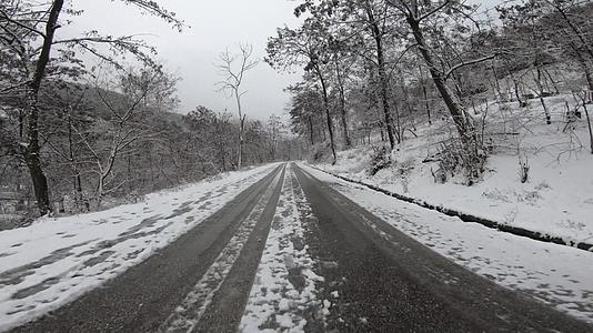 在白色和雪地的路上驾驶一辆强风的汽车视频的预览图