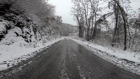 在冰雪覆盖的农村道路上驾驶汽车视频的预览图