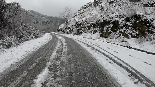 在冰雪覆盖的农村道路上缓慢而谨慎地行驶视频的预览图