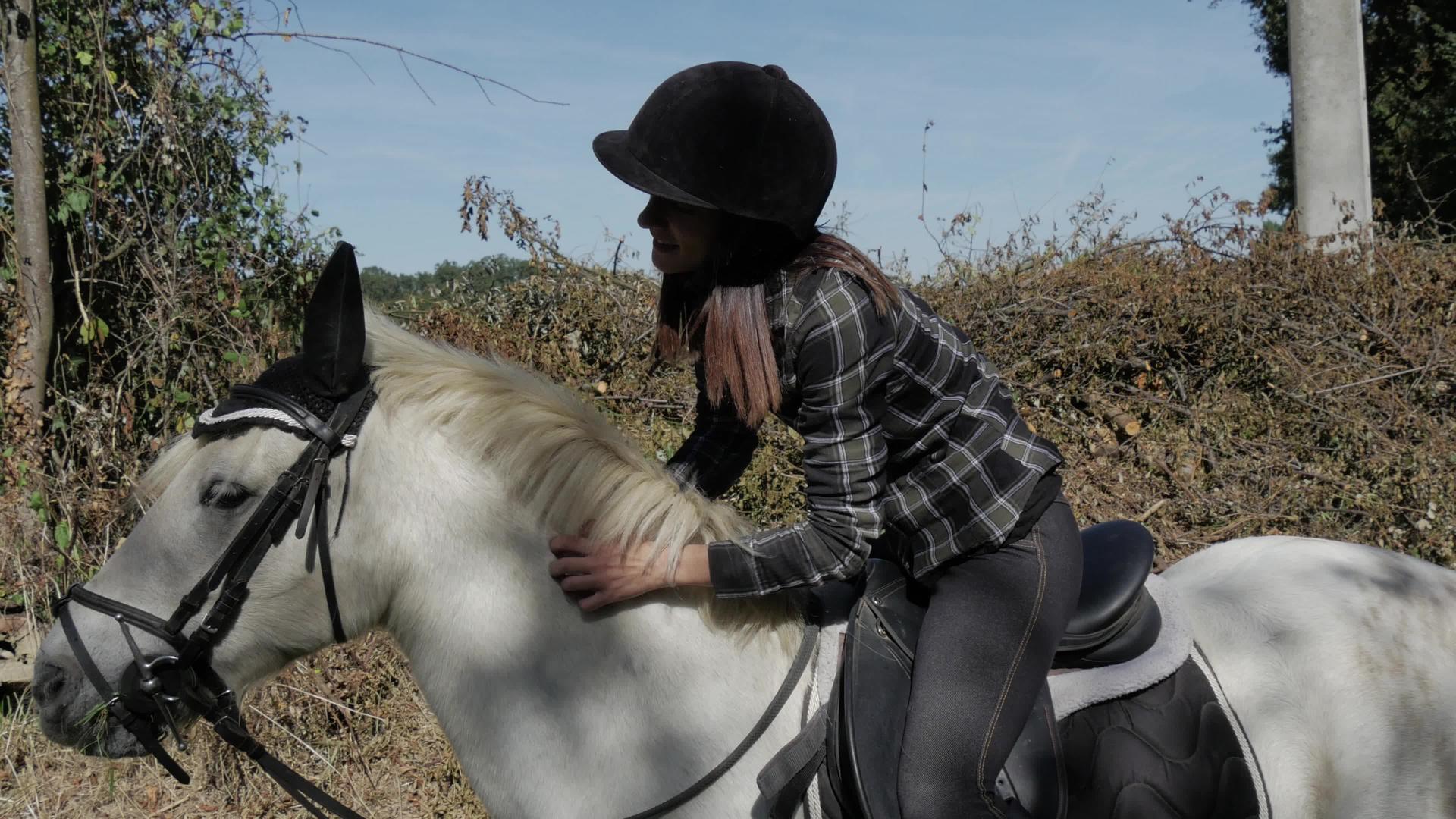 美丽的年轻女子骑着白马骑自行车视频的预览图