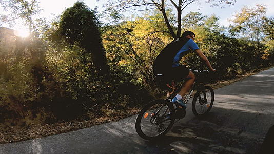 骑自行车的男子在开阔的乡村道路上慢慢移动视频的预览图