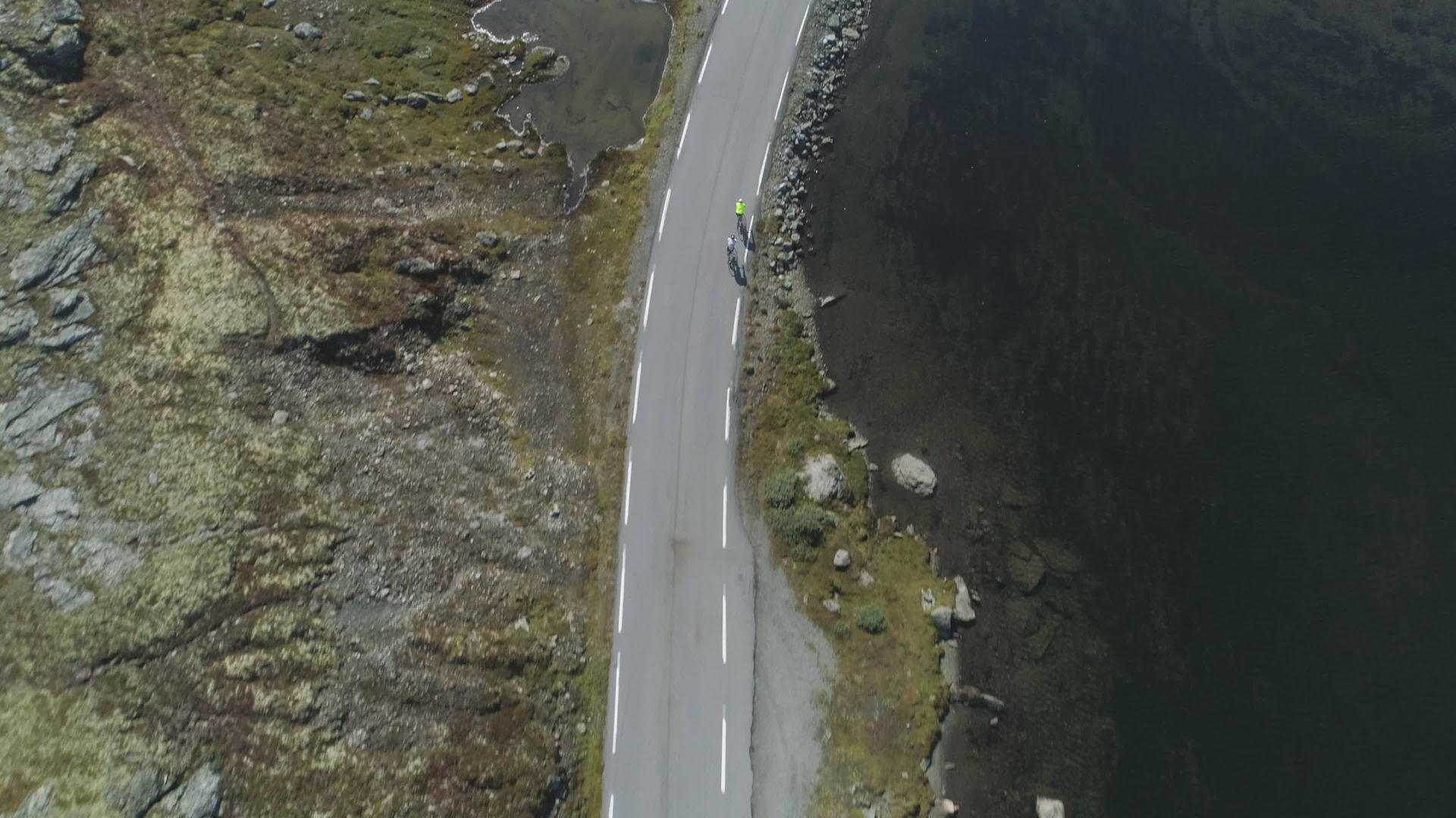 在阳光明媚的夏天职业自行车手戴着头盔在挪威的山路上视频的预览图