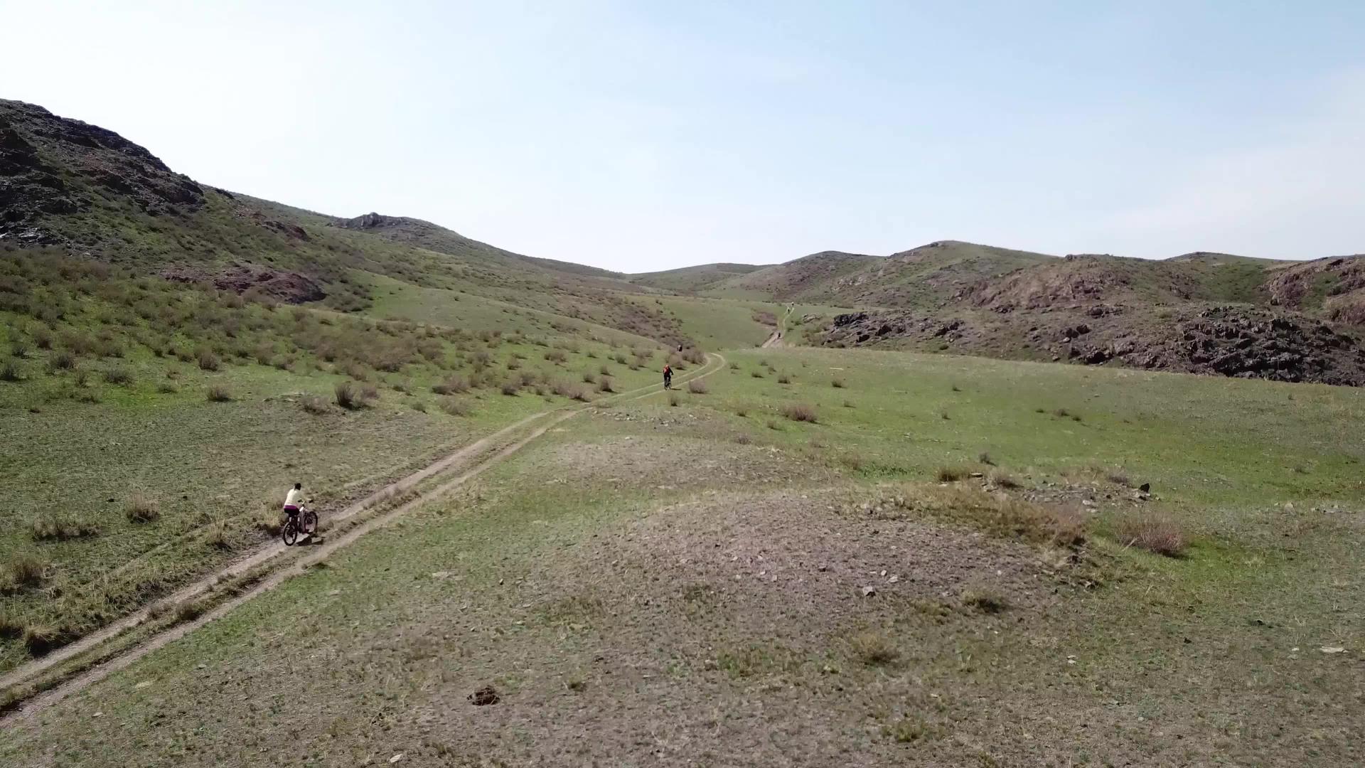 一群骑自行车的骑手骑在绿色的草原上视频的预览图
