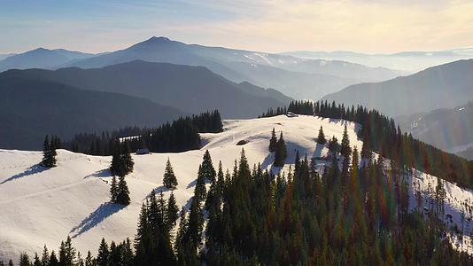 日出时罗马喀尔巴阡山脉的空中有绿林和雪山视频的预览图