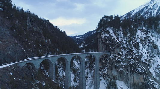有铁路的Landwasser高架桥位于冬山峡谷和河流视频的预览图