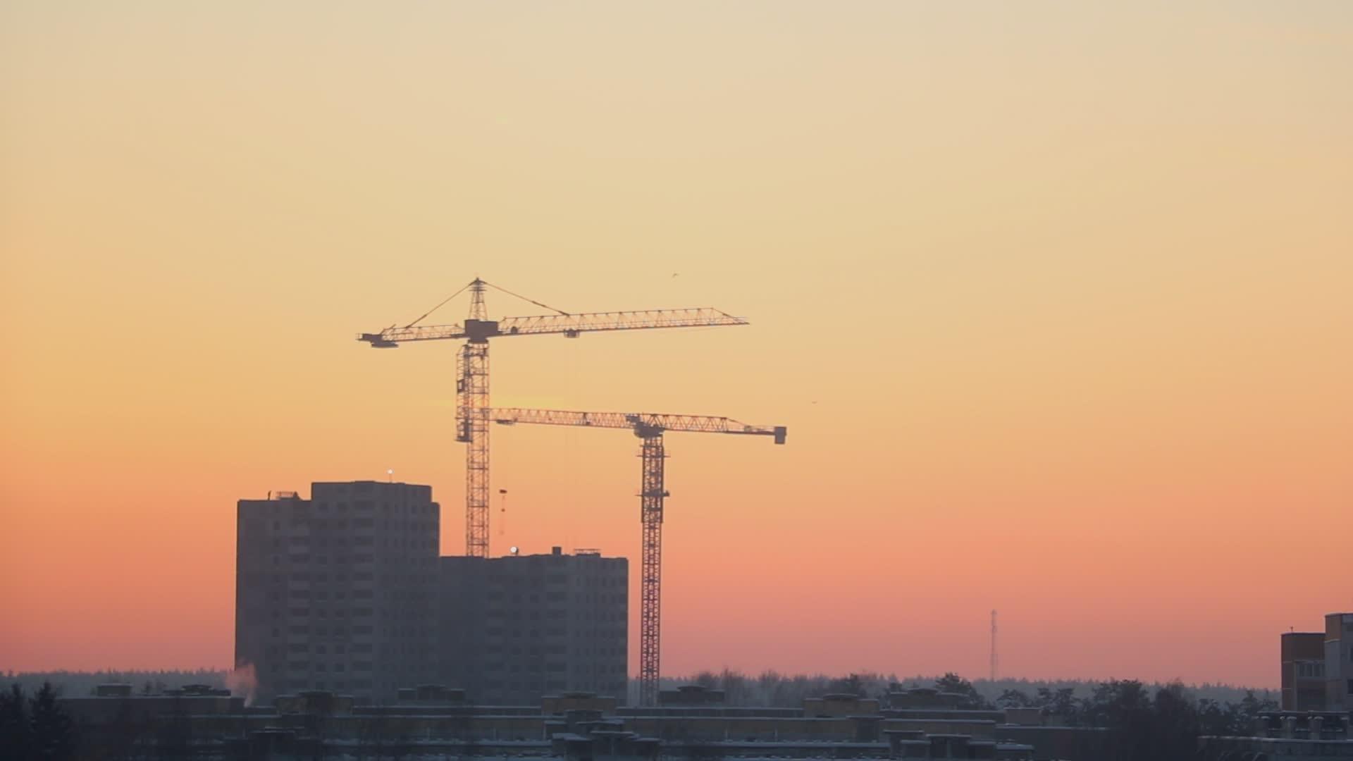 建筑工人和高塔起重机在建造房屋期间的工作时间已经过去视频的预览图