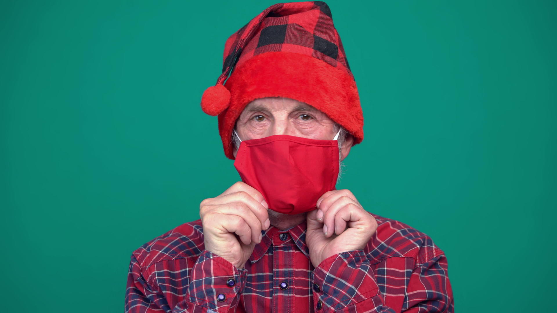 戴着红色医疗面具的成熟男子戴着圣塔帽的肖像视频的预览图