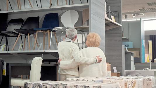 一对可爱的老夫妇在商店里选择了家具的后视镜头视频的预览图