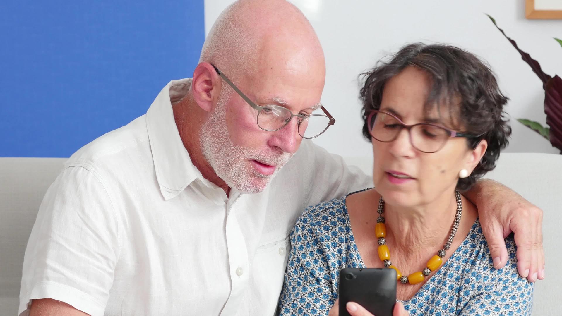 老年夫妇用智能手机微笑视频的预览图
