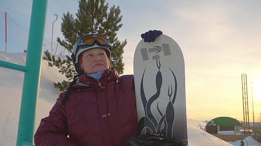 高级女滑雪运动员在山上的冬季度假胜地放置滑雪板视频的预览图
