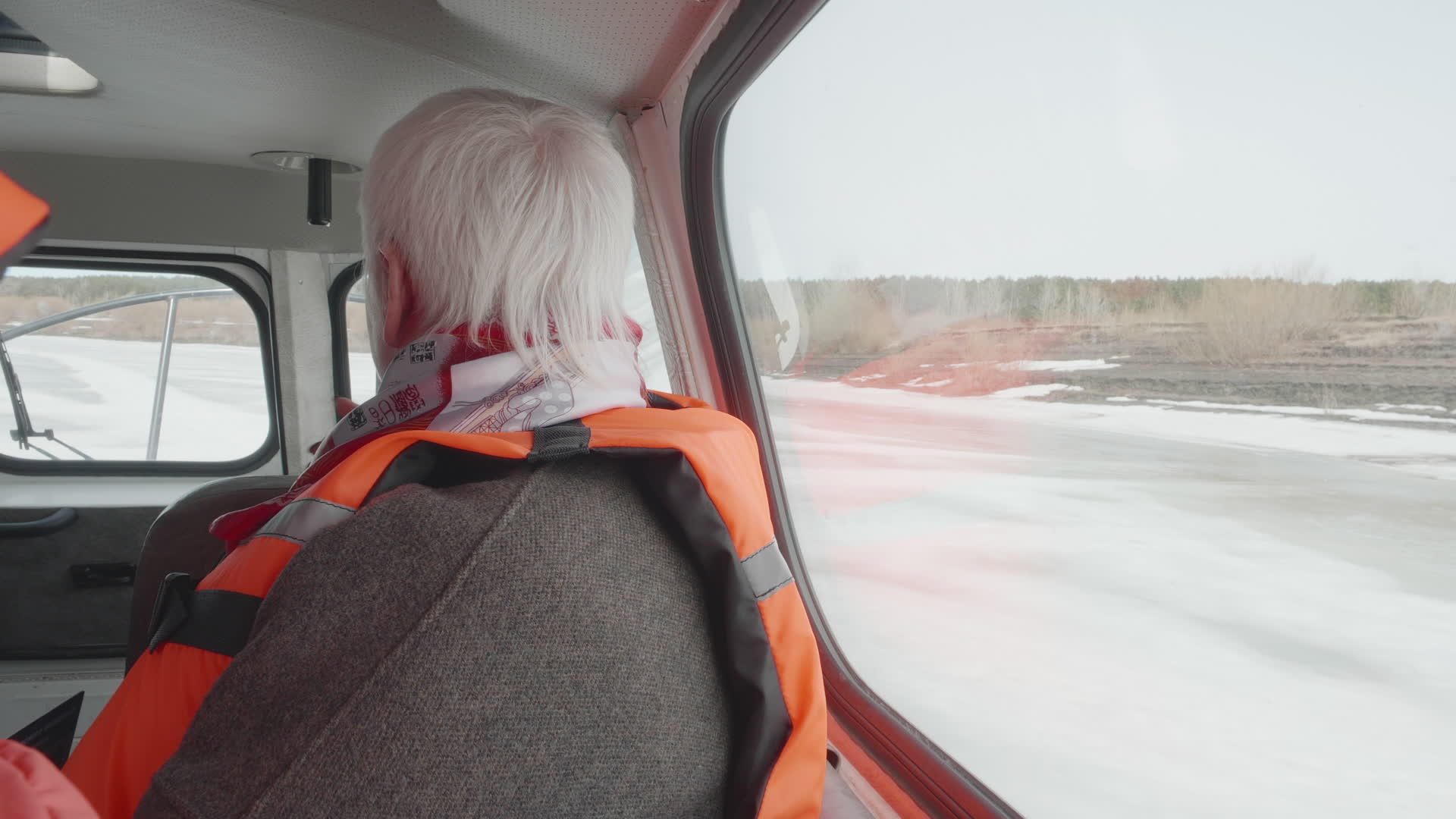 冬天穿着安全夹克的高级女性在冰冻的河流上乘坐气垫船视频的预览图