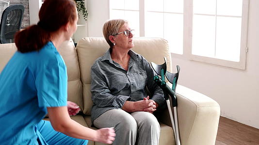 养老院的女护士与老年妇女和老年人交谈视频的预览图